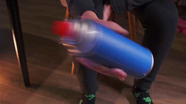 Shaking pressurized canister before use, could be gas fuel or spray paint container, preparation process for even distribution and proper function at home environment