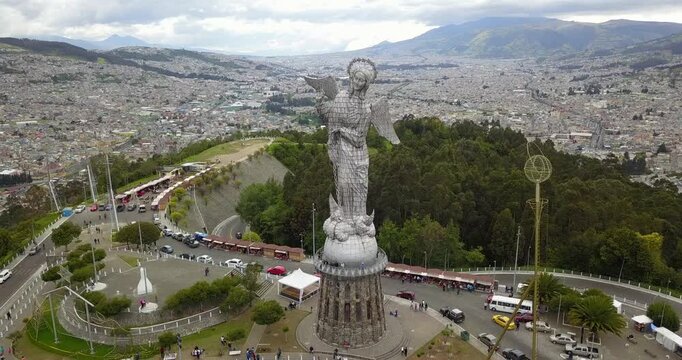 Aerial orbit of Virgin of El Panecillo statue in Quito Ecuador with city skyline background