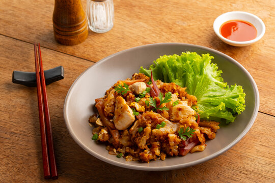 Stir fried Rice Noodles with Chicken.stir fry flat noodles with chicken ,Pickled squid and egg in a plate. (Kuay Teow Kua Gai)