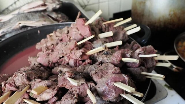 Brochettes de viande en pr&eacute;paration dans une po&ecirc;le, d&eacute;tail de cuisine lors d&rsquo;un mariage