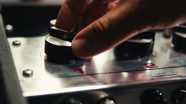 Music studio close up, Close up hands shot of sound engineer using mixing console, remote control for adjusting sound, audio mixer. Musician creates music, makes remix for DJ set. Sound recording