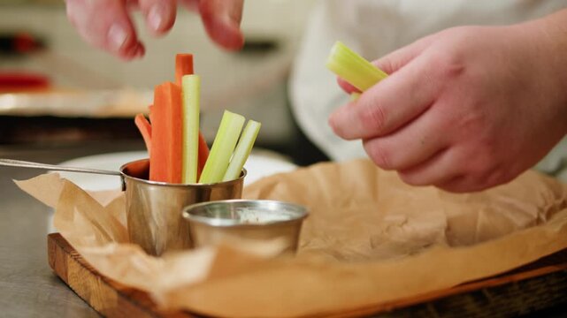 Chef cooking on professional kitchen in restaurant, making salad on plate, serving. Culinary preparation on kitchen.