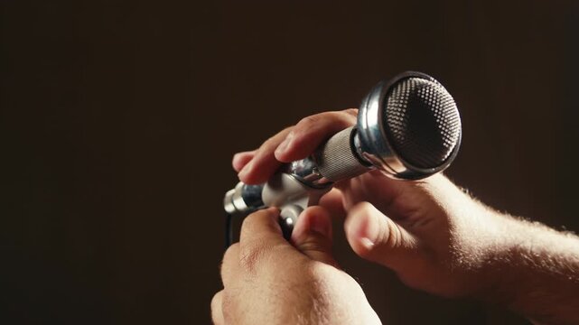 Retro microphone on studio or stage, macro of check sound, hand touch microphone. 