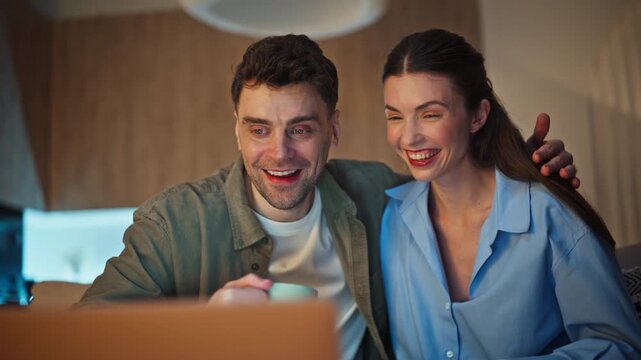 Videocalling pair speaking online talking virtual laptop sitting couch closeup