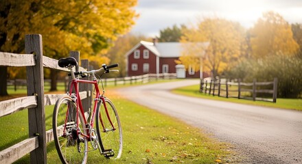 Fototapeta premium Rustic Red Bicycle Leans Against Wooden Fence On A Serene Autumn Road