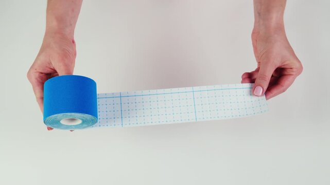 Kinesiology medical taping, doctor Physical therapist applying elastic surgical tape to patient body, treating injured knee young athlete.Post traumatic rehabilitation, sport physical therapy recovery