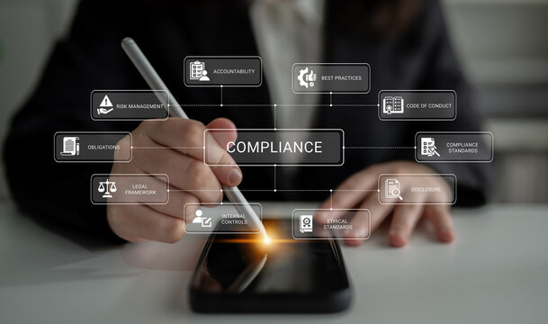 A professional uses a stylus on a smartphone to illustrate critical compliance concepts, showcasing a blend of technology and business practices in a modern work environment. Ledger