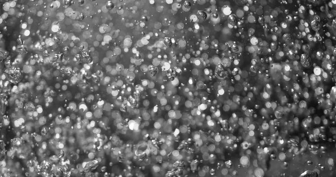 Super slow motion (1000 fps) macro of bubbles rising in water. Smooth underwater motion with sparkling highlights, creating abstract fluid background and dynamic texture.