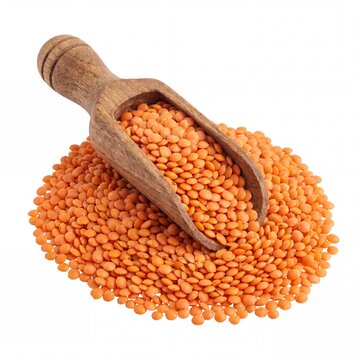 Pile of raw red lentils with a wooden scoop on white