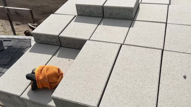 New concrete paving slabs stacked on pallet at construction site, closeup texture.