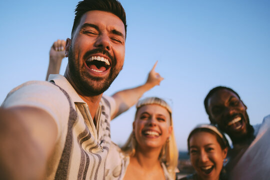 Happy young people smiling and taking a selfie together outdoors