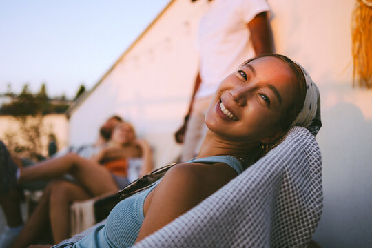 Young asian woman smiling relaxing with friends at sunset party