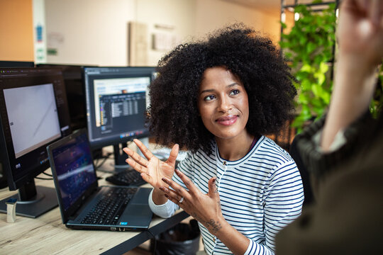 Professional discussing project at computer in modern office