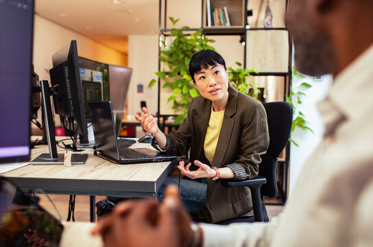Manager explaining project to colleague in modern office