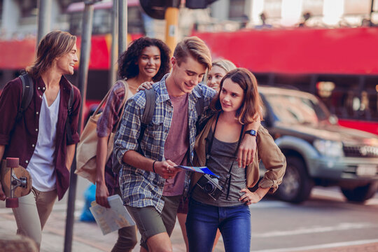 Group of young friends exploring city streets with a map