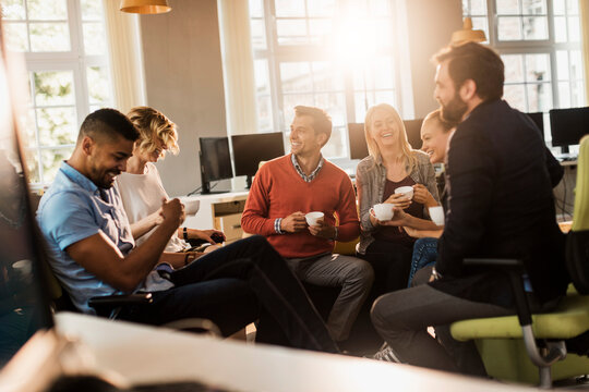 Coworkers enjoying coffee break in modern office