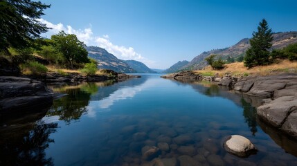 Obraz premium A tranquil expansive river reflects the brilliant blue sky and lush surrounding mountains