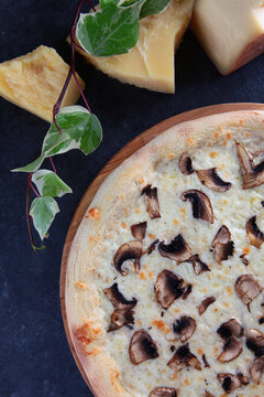 Pizza with chicken and champignons. Traditional Italian cuisine. Pieces of hard aged parmesan cheese. Flat lay. Top view