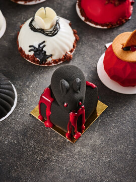 This assortment features intricately designed Halloween-themed cakes with various colors and textures. Perfect for bakery menus, party catering, and promotional materials during the festive season