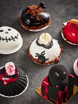 This collection features Halloween themed mini cakes adorned with spooky decorations. Ideal for advertising Halloween events, bakery promotions, or festive menu items