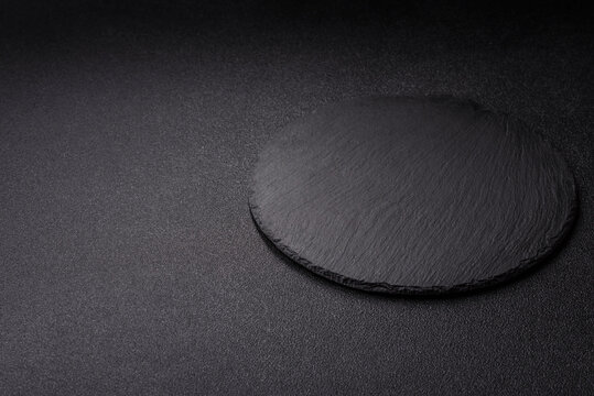 A blank slate board on a dark background for Asian food. A blank slate board