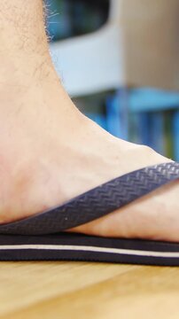 Flat feet in flip-flops step in frame slow motion