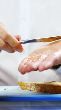 Person spread honey on hand instead on bread close-up