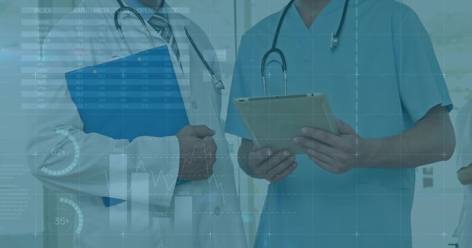 Reviewing data, two med staff in lab coat and scrubs consulting in clinic with tablet, stethoscopes