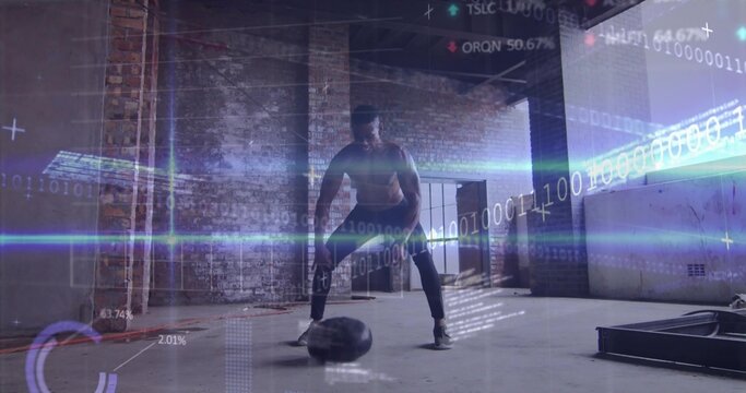 Slamming shirtless man in leggings and shoes, powering medicine ball in warehouse with HUD overlays