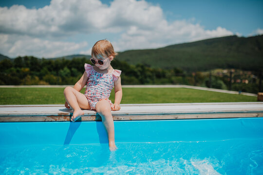 Little girl enjoying summer by the pool