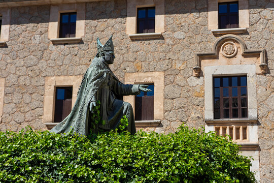 Mallorca, Spanien: Wanderung auf dem GR 221 zum Kloster Lluc, Santuari de Santa Maria de Lluc - Sehensw&uuml;rdigkeit f&uuml;r Touristen: das Geb&auml;ude mit Statue im Garten, Innenhof