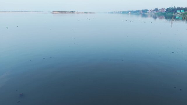 Drone editorial coverage of Fatuha's Triveni Ghat. A native freshwater dolphin navigating the polluted urban confluence of the Ganges and Punpun.