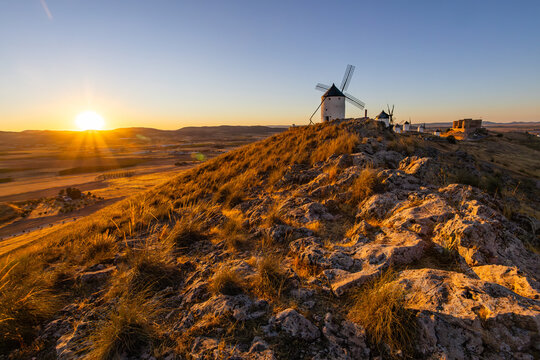 Consuegra windmills on hill during golden sunset