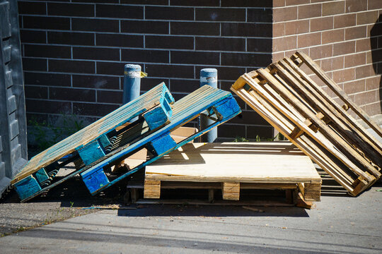 Stack of trash wooden pallets in urban alley 