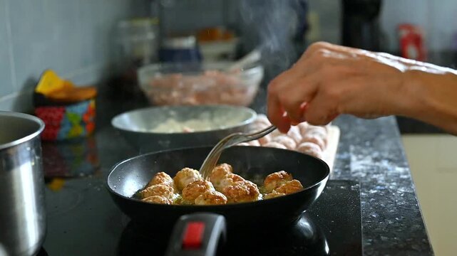 homemade meatballs cooking process in home kitchen, frying pan with olive oil and ingredients on countertop, woman preparing food, traditional Mediterranean recipe lifestyle scene