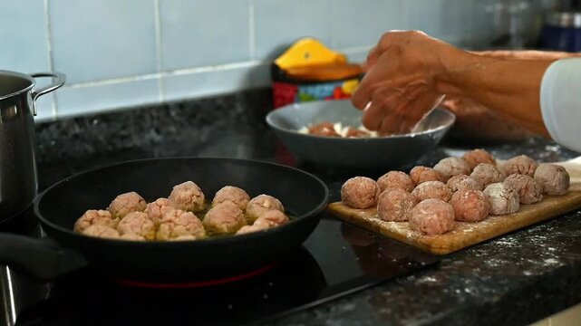 Homemade meatballs frying in pan with olive oil, Mediterranean family cooking scene, traditional minced meat recipe preparation, home kitchen food process, rustic homemade meal concept
