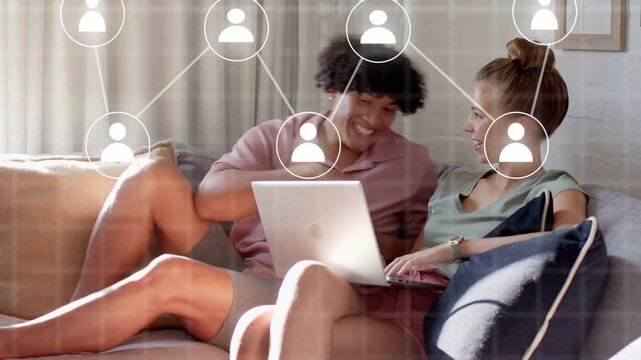 Man pointing and guiding woman typing on laptop, animated user icons growing into tech network
