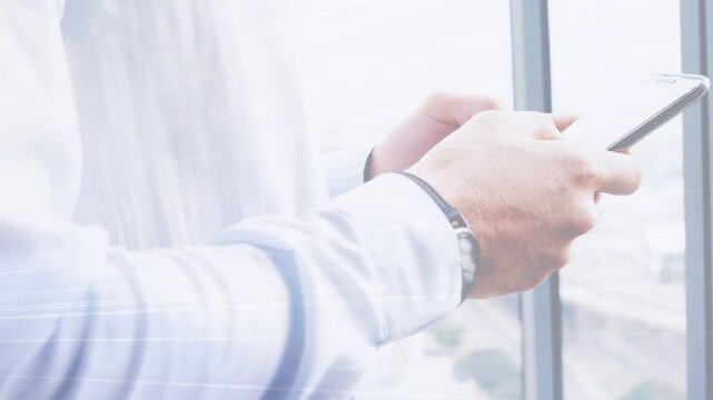 Businessman holding phone by window streaks reflecting angling phone tapping swiping reviewing data