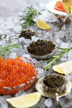 Red and black caviar. Caviar is served with ice. A natural omega and a delicacy for the festive table. Slices of lemon are placed next to the caviar.