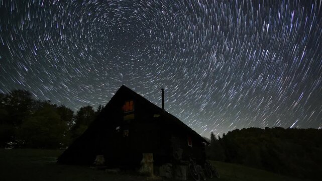 Stars Rotating Over Remote Wooden Hut in Forest Wilderness at Night Timelapse