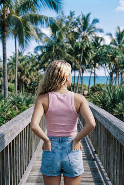 Woman walking on boardwalk enjoying tropical ocean view