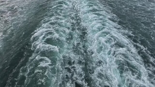 Glacier Bay, Alaska, USA - Close aerial of vessel wake cutting through the water surface. The wake creates texture and pattern in the ocean sea water.