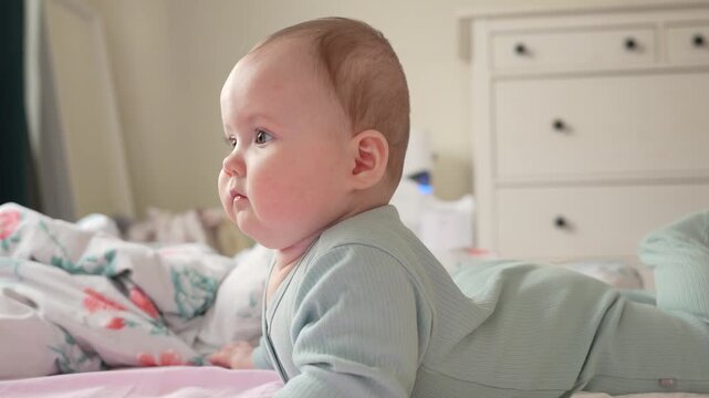 Cute 7 month old baby girl playing and making fun while tummy time. 