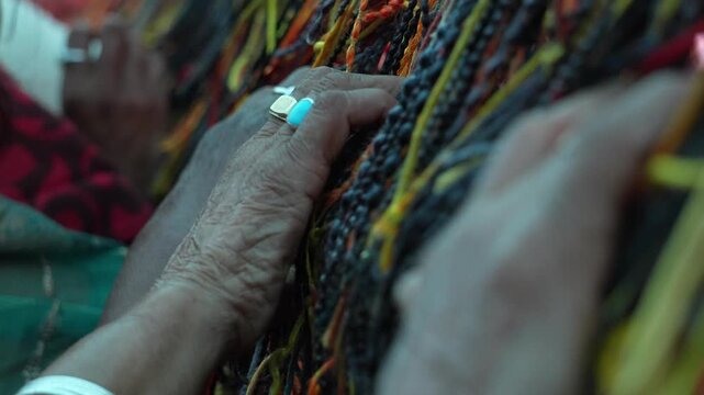Close-Up of Hands Working with Colorful Threads spitual hindu dharma concept