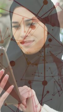 Vertical video: Woman in headscarf tapping tablet to browse tech content, network overlay following