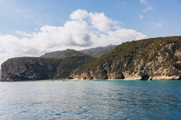 Naklejka premium Cala Luna beach in the Gulf of Orosei, Sardinia, Italy, with coastal cliffs, sea grottos, and turquoise Mediterranean water
