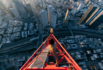 Silhouette of an urban climber on a crane against the night sky © Алексей Голубев