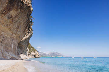 Fototapeta premium Cala Luna beach with turquoise Tyrrhenian Sea and limestone cliffs overlooking the Gulf of Orosei, Sardinia, Italy