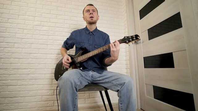 A talented guitarist is passionately playing in a stylish modern interior, showcasing both creativity and musical skill