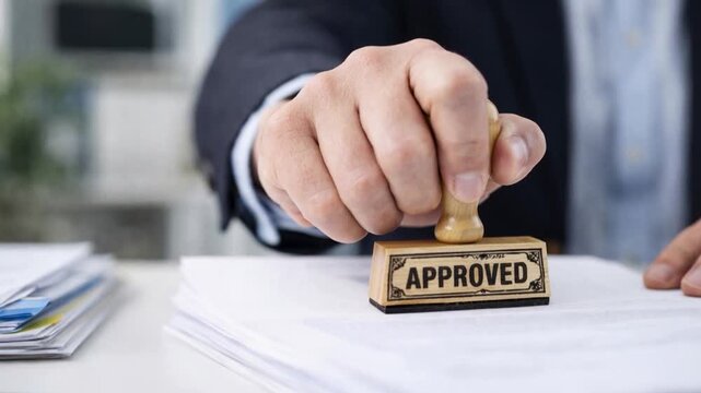 Hand stamping a document with a seal.
